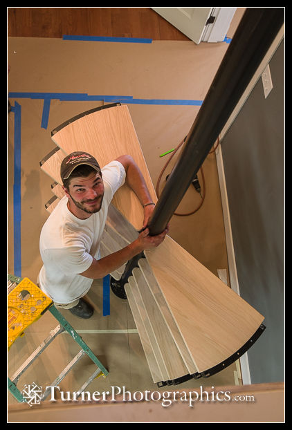 Matt holds spiral staircase pole in position