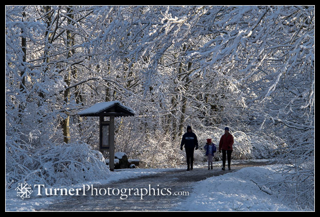 Family walks snowy Railroad Trail