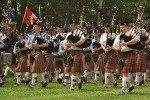 0503613 Bagpipers in massed pipe band march off field, opening ceremony. Bellingham Highland Games, Ferndale, WA. © Mark Turner