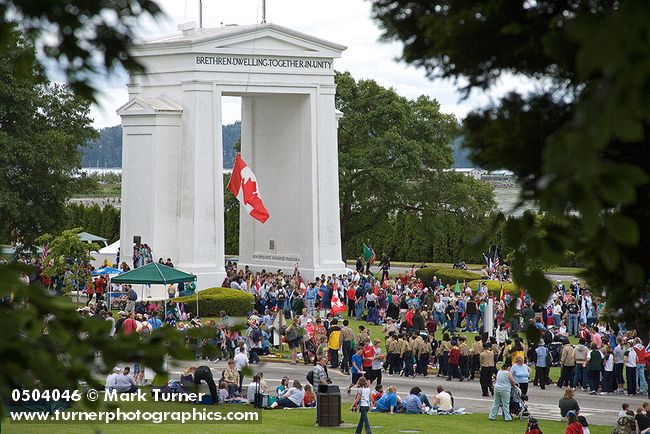 0504046 Scouts march through Peace Arch in Hands Across the Border celebration, framed by trees. Blaine, Peace Arch Park, WA. © Mark Turner