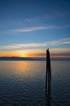 0700138 Sunset over Bellingham Bay w/ silhouette of seagull on piling, Lummi Island bkgnd. Bellingham, Boulevard Park, WA. © Mark Turner