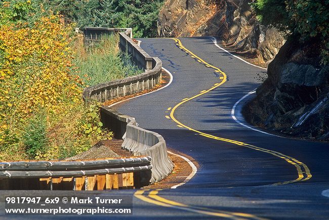 9817947 Curving two-lane blacktop highway w/ concrete railing. Skagit Co. Chuckanut Dr, WA. © Mark Turner