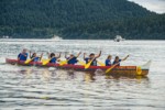 0504337 Boys & girls (junior buckskins 13 & under) paddle 11-man canoe to finish, Lummi Stommish canoe races. Lummi Nation, WA. © Mark Turner