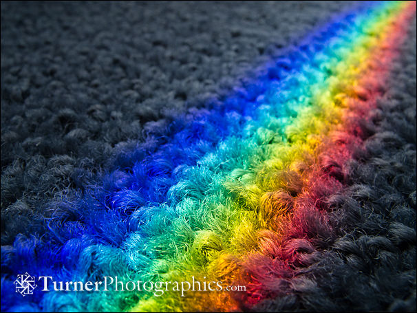 Rainbow on carpet from prism effect of glass shelf